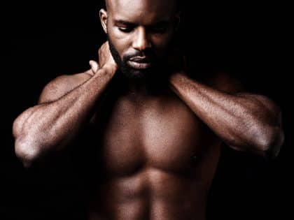 Six pack perfection. Studio shot of a muscular man closing his eyes while holding his neck